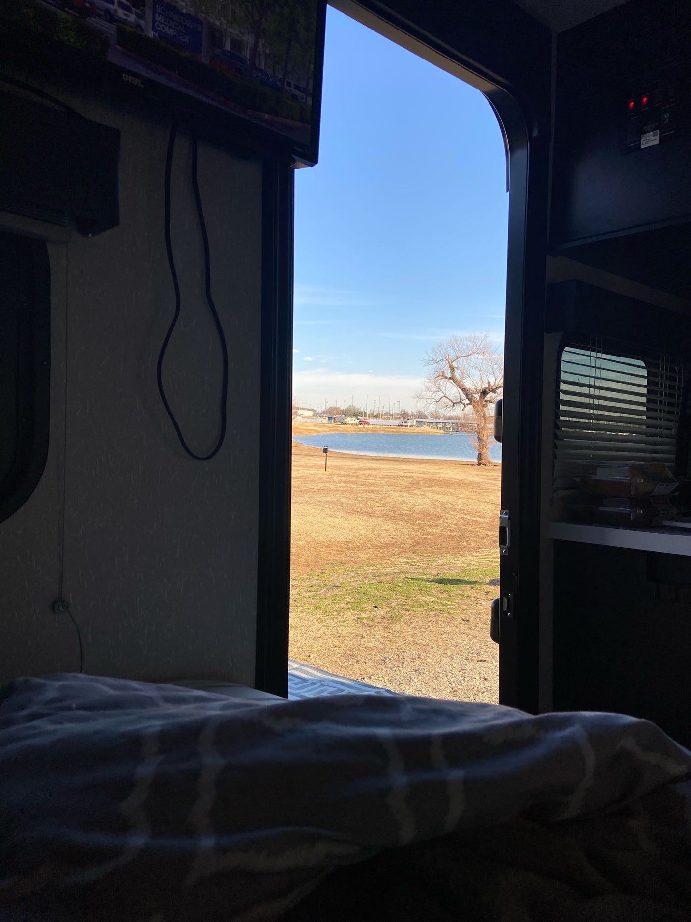 Enjoying the lake view from an RV rental. Cozy travel setup with an open door to nature. Ideal for serene camping.