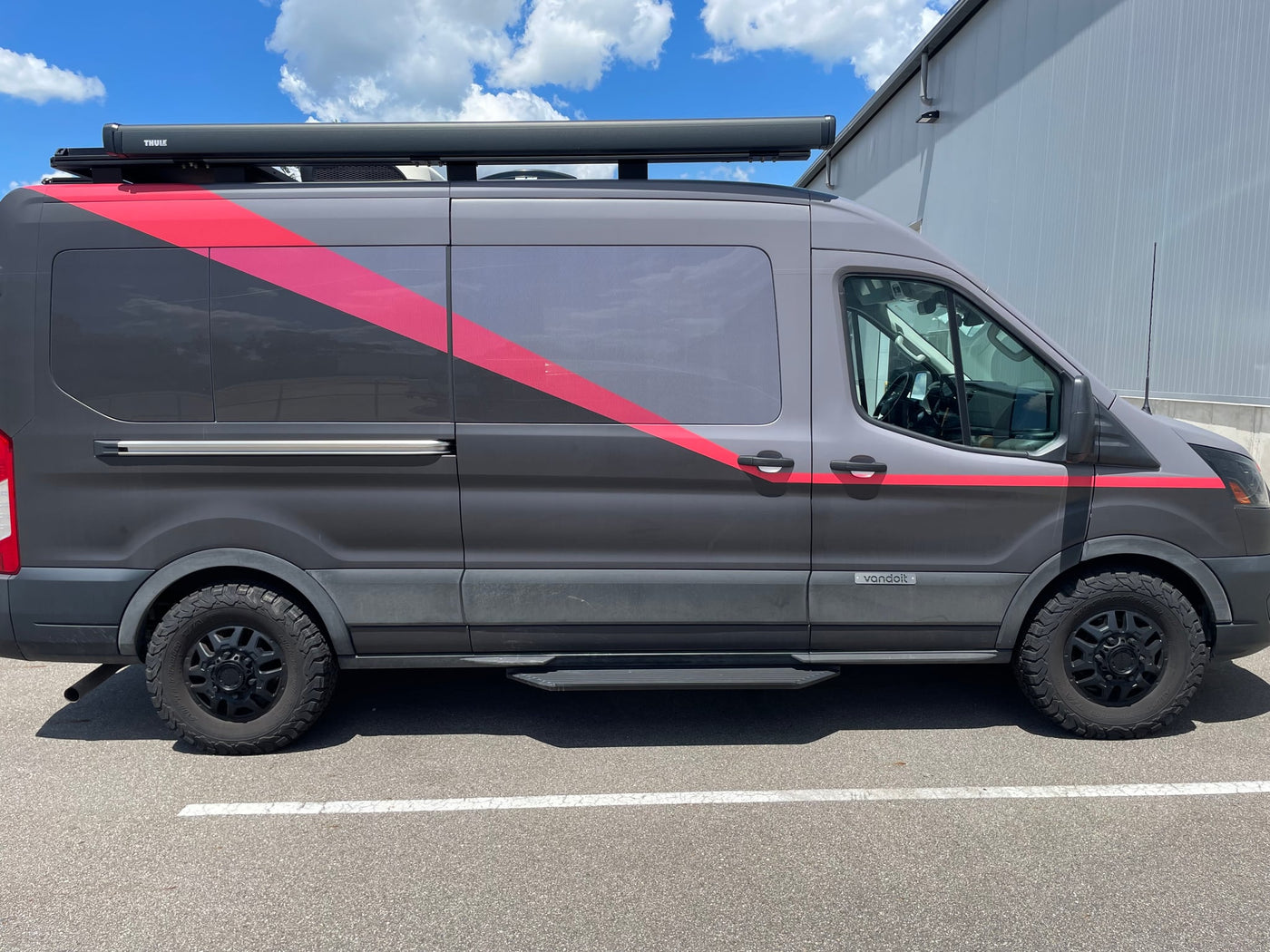 A gray Vandoit rv rental adventure van with red stripes — photo 1