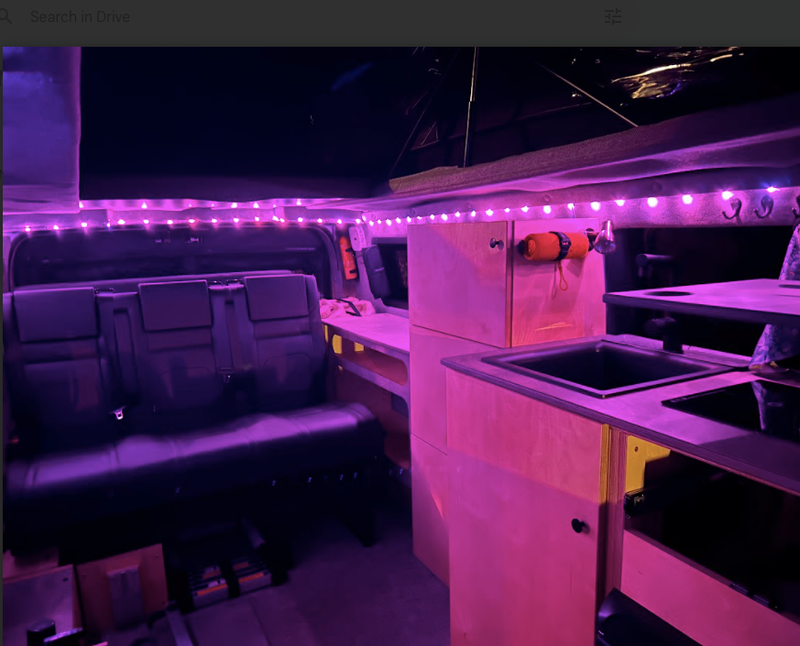 Step inside this cozy RV rental! Features rear seats, built-in kitchen with sink/stove, and ambient LED lighting. — photo 14