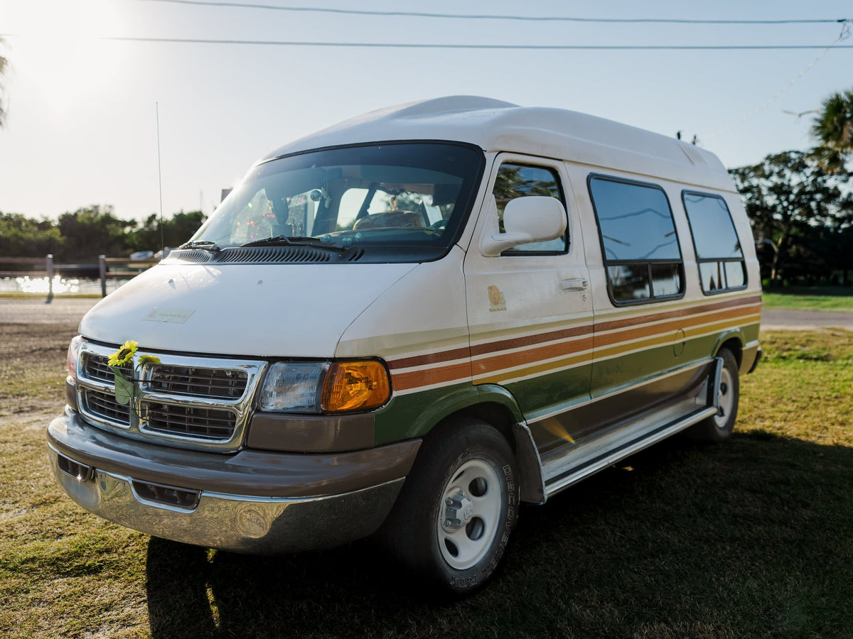  hammock-equipped interior. Perfect for van life adventures!|White retro camper van RV rental with open doors revealing a hammock inside & chairs outside on grass. Ideal for van life travel.|Retro striped camper van — photo 3