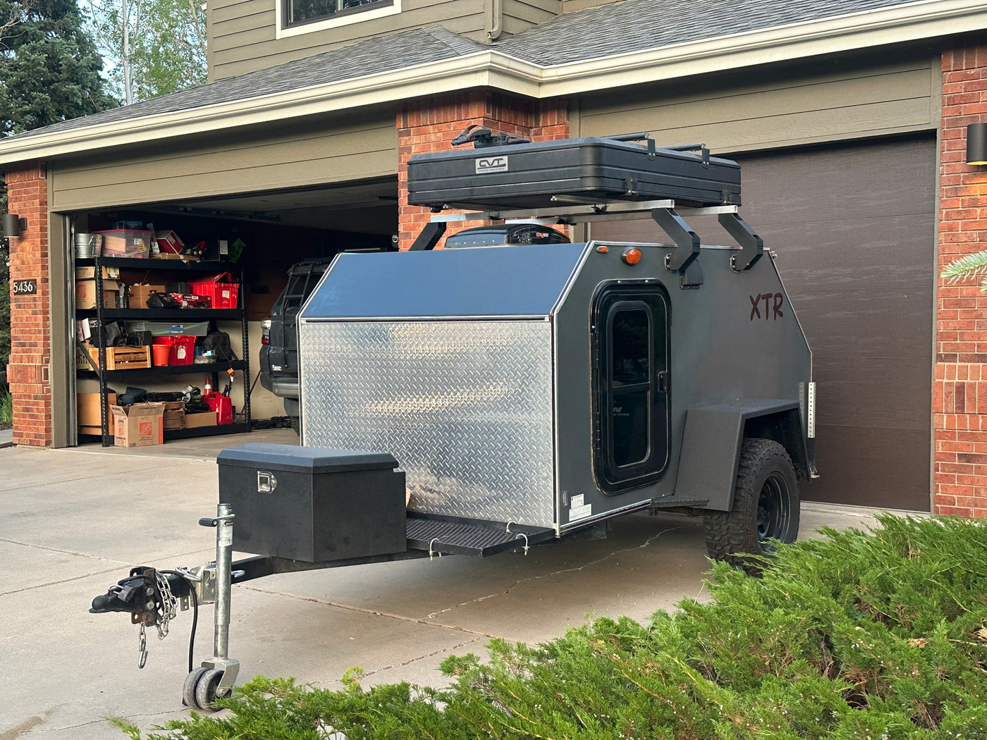 This gray overland camper trailer with a rooftop tent, ideal for an RV rental trip, is parked in a residential driveway. — photo 5