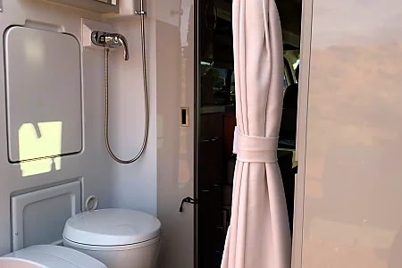  and outside view. Perfect for road trip cooking.|Bright RV rental interior showing a compact kitchen — photo 4