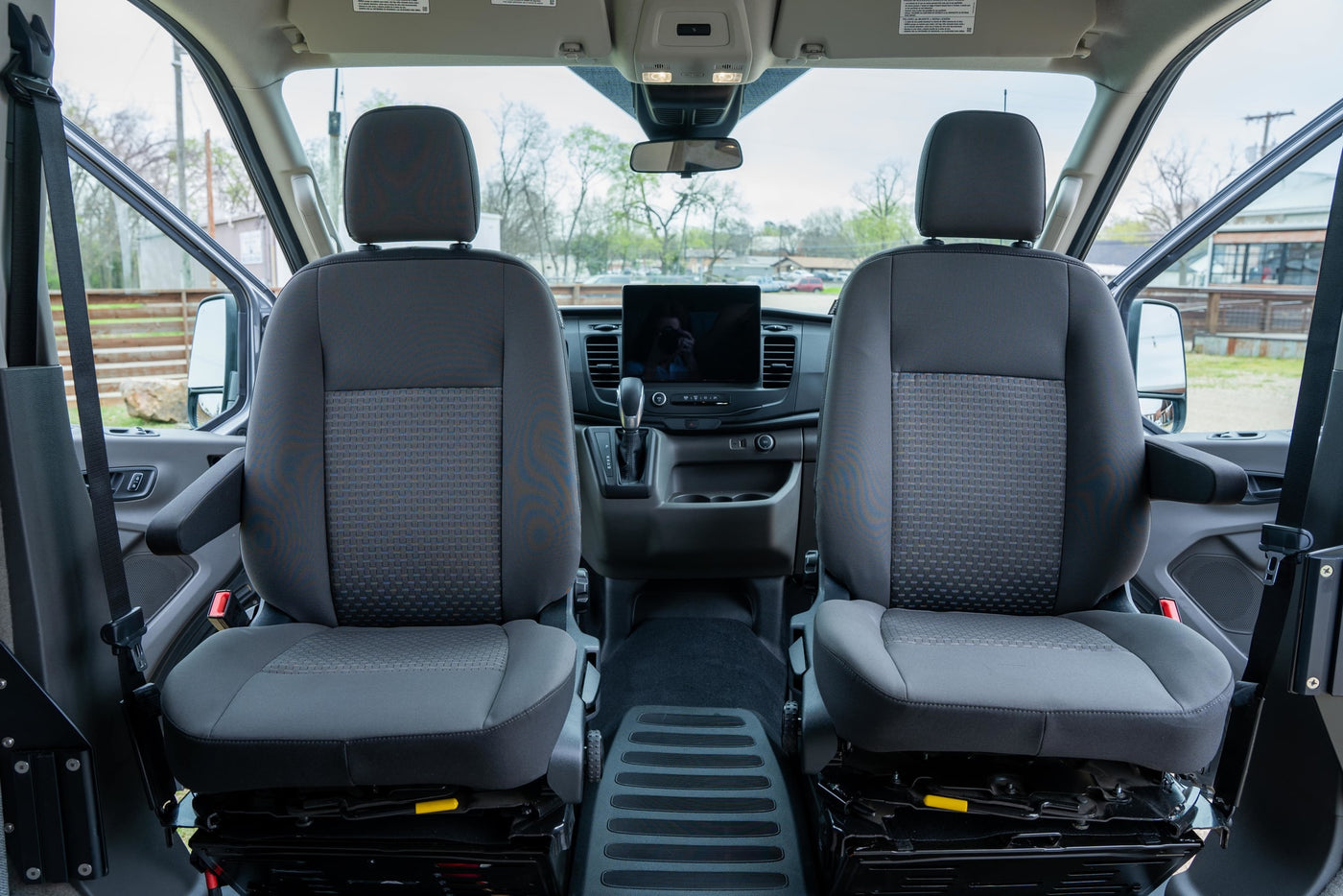  is parked on a dirt lot under string lights.|This sleek grey Ford Transit camper van — photo 11