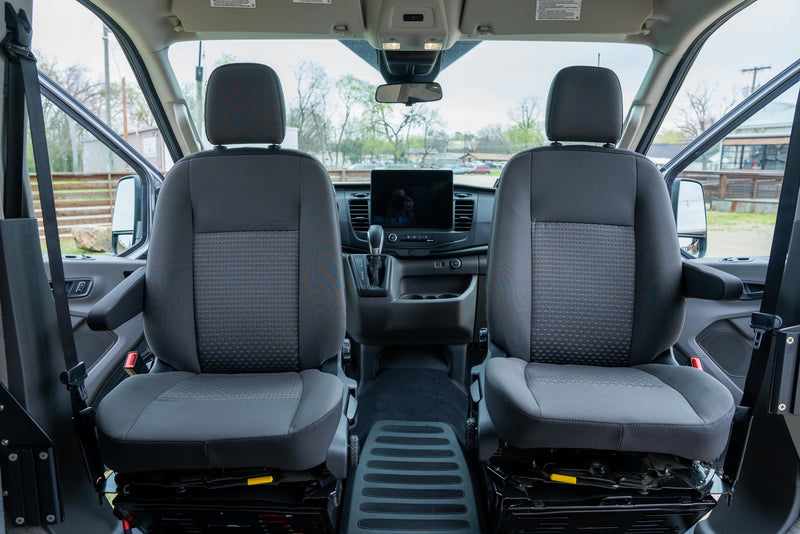  is parked on a dirt lot under string lights.|This sleek grey Ford Transit camper van — photo 11