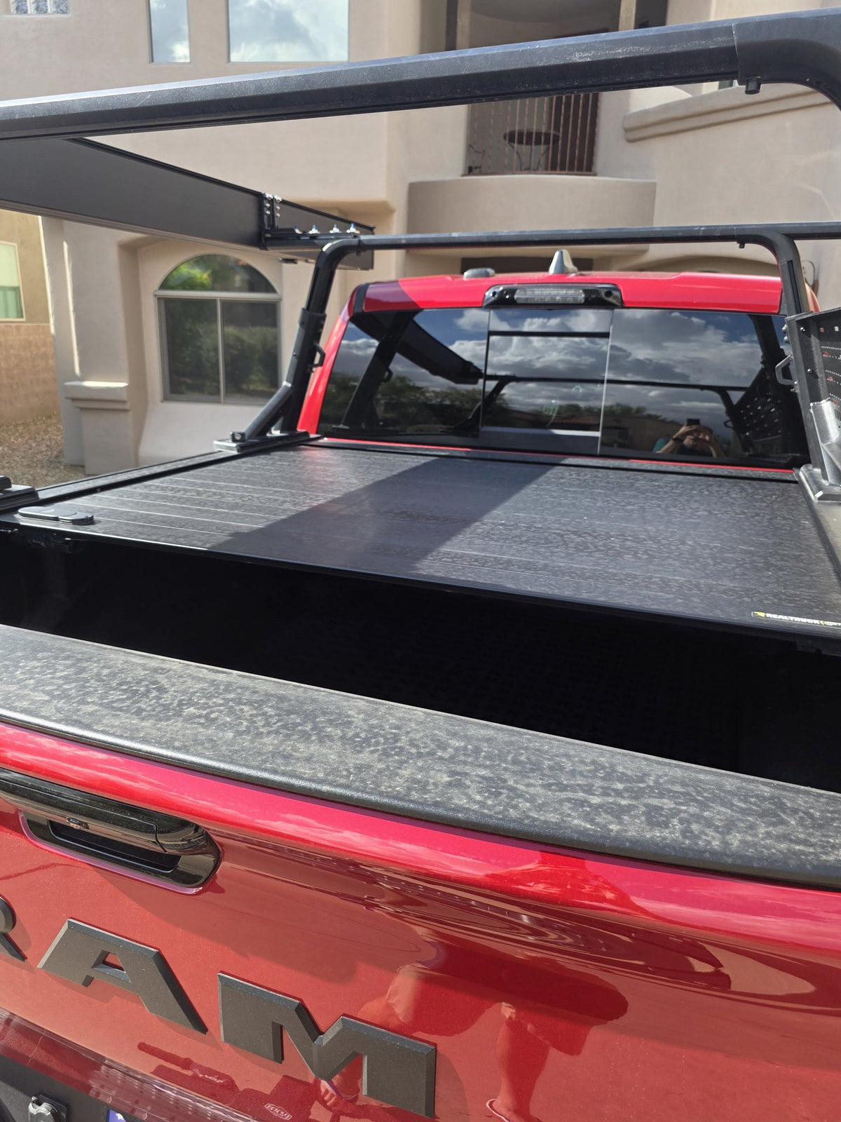 Close view of the Retrax Pro XR cover slats across the RAM 1500 bed with the Yakima OverHaul HD rack uprights and crossbars above — photo 2