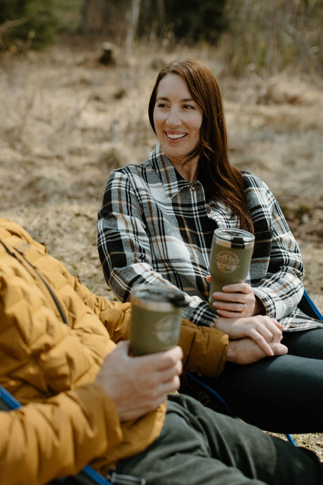 Smiling couple enjoying coffee outdoors, perfect for an RV rental getaway.
