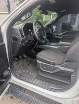 Inside a white Ford F-150 truck, showcasing the driver's side cabin, ideal for an RV rental adventure.