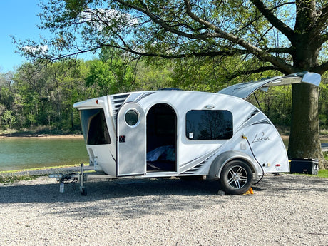  viewed from an rv rental. Teardrop camper and cooler at a beautiful campsite.|This "Luna" teardrop RV rental is perfectly parked by a tranquil lake