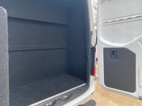 Spacious, black-lined van interior, ready for RV rental. Ample cargo space for your next campervan adventure.