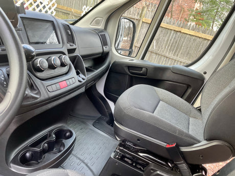 RV rental van's passenger interior: dashboard with Pioneer screen, climate controls, cupholders, and fabric seat.