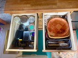 Organized RV rental drawers with kitchenware, utensils, jars, and utility items. Perfect for compact living on the road.