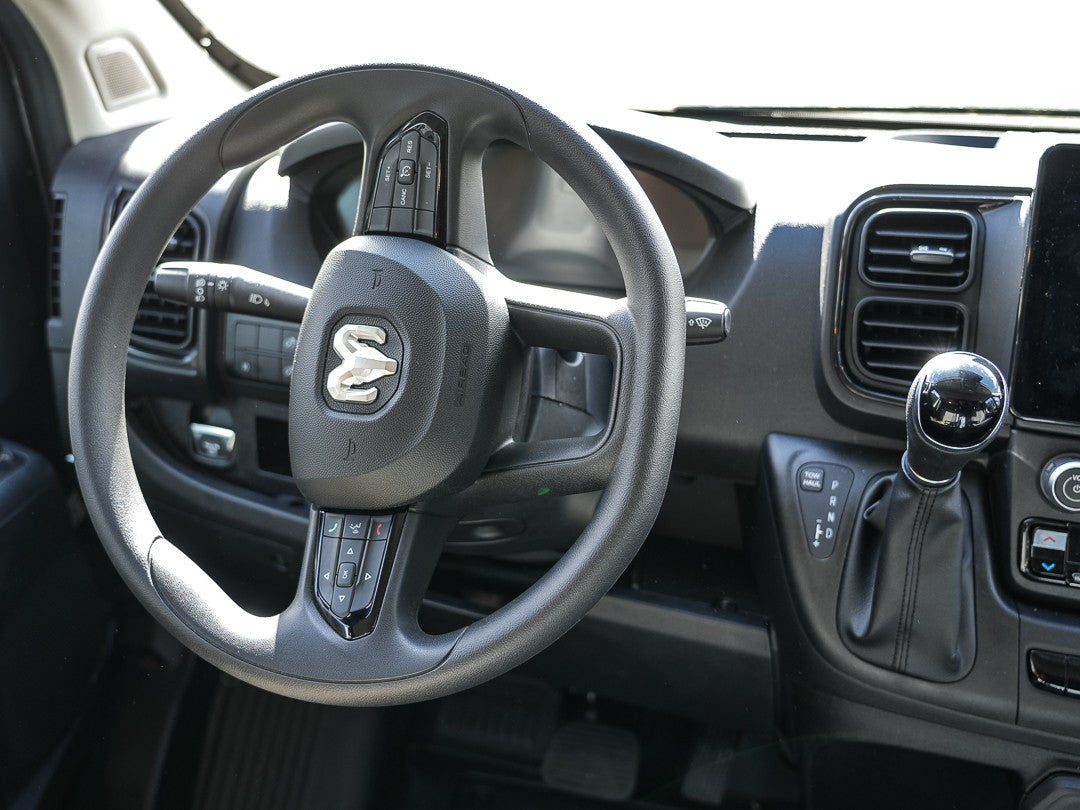 RV rental interior: driver's seat with RAM steering wheel, dashboard controls, and automatic shifter.