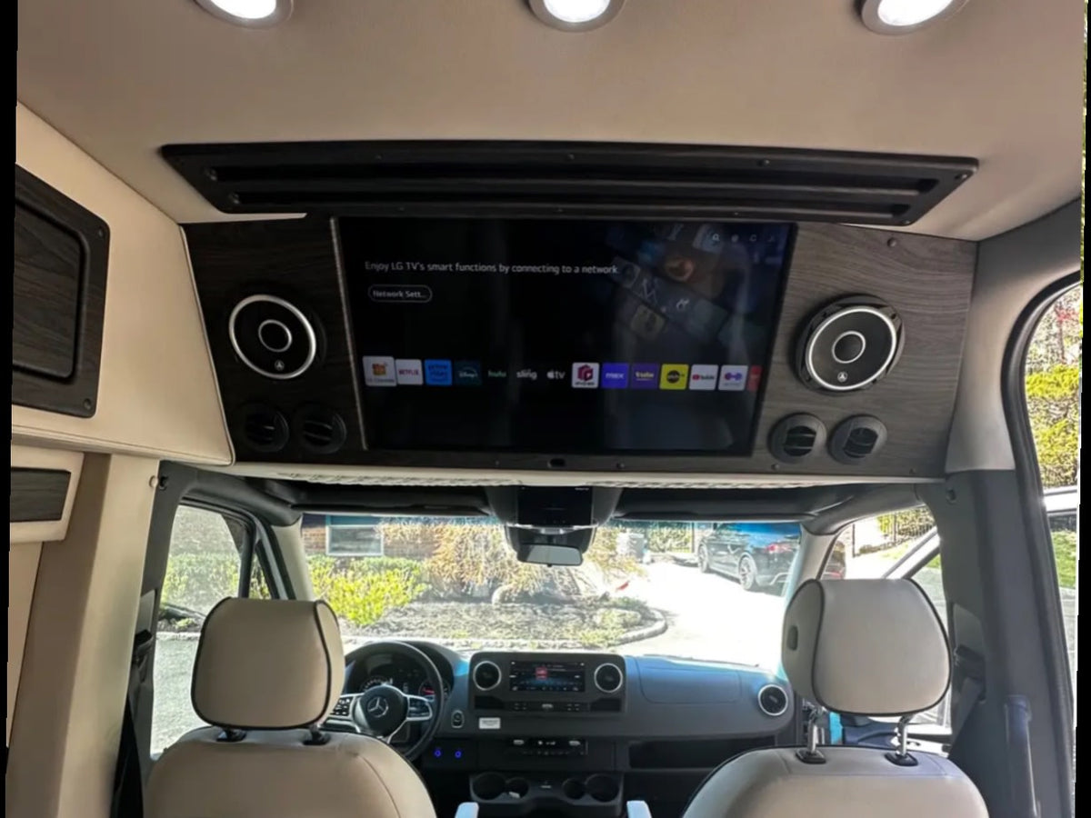  a luxury conversion van with a black hood & custom body kit.|Luxury RV rental interior: overhead smart TV with streaming apps — photo 2