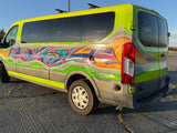 Vibrant RV rental van with unique graffiti art on its lime green exterior, showcasing a dynamic custom design.