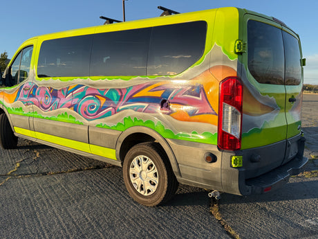 Vibrant RV rental van with unique graffiti art on its lime green exterior, showcasing a dynamic custom design.