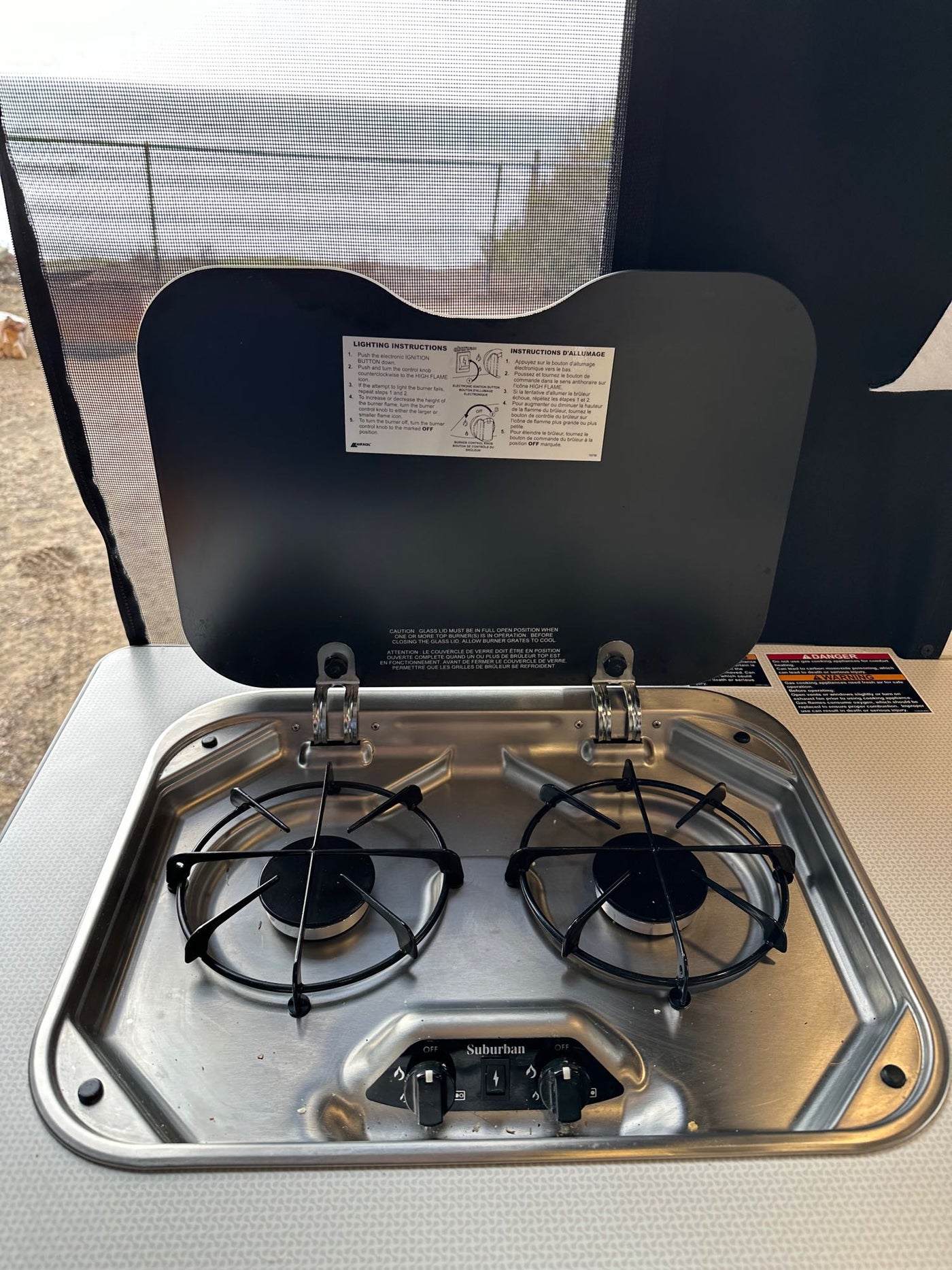  a digital rearview mirror shows a coastal path with gnarled trees and ocean. Windshield view.|RV rental dashboard with digital infotainment screen showing navigation — photo 13