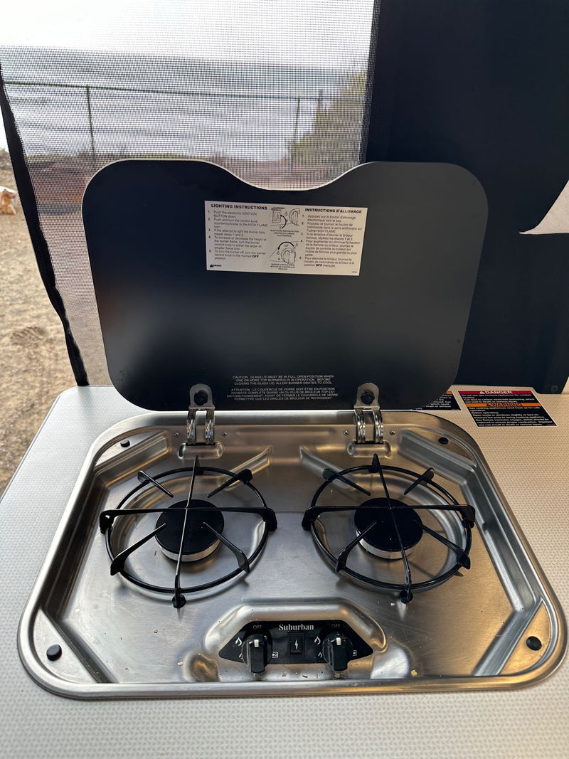  a digital rearview mirror shows a coastal path with gnarled trees and ocean. Windshield view.|RV rental dashboard with digital infotainment screen showing navigation — photo 13