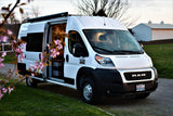 White Ram ProMaster RV rental, a versatile camper van with its side door open, ideal for travel and van life adventures.