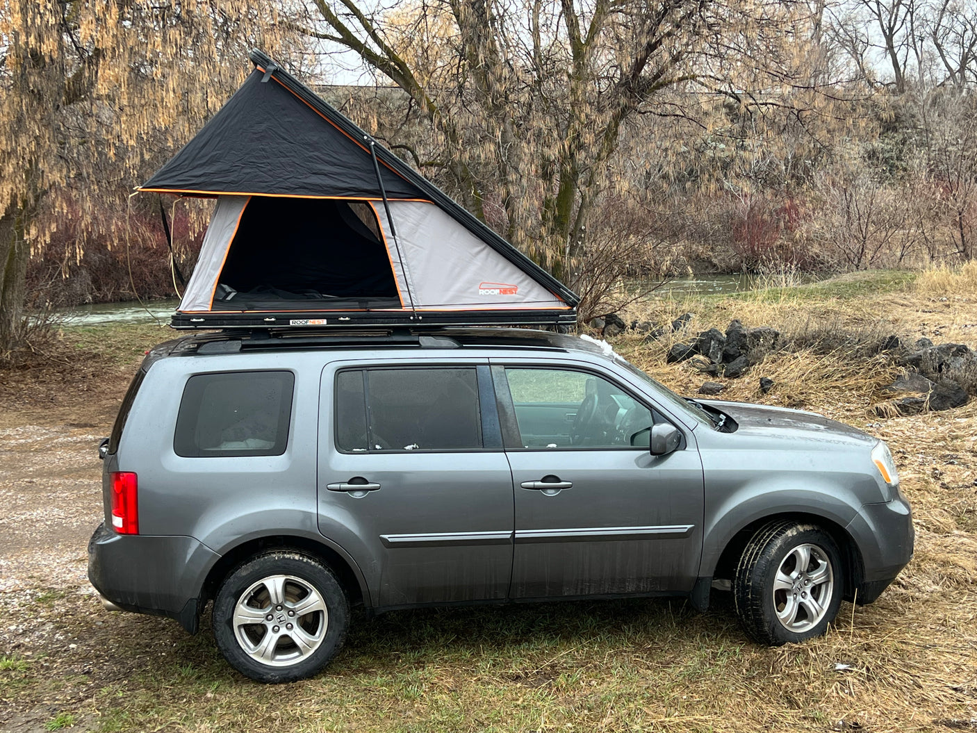 Grey SUV with a Roofnest rooftop tent, an ideal RV rental option for comfortable camping and outdoor adventures.