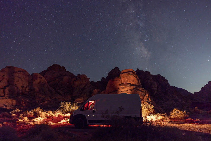 White RV rental van with red interior light, parked in a desert landscape under the starry Milky Way. — photo 19
