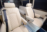 Luxury RV rental interior: plush cream quilted leather captain seats and bench seating ensure comfortable travel.