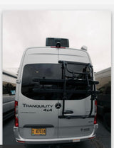 White Thor Tranquility 4x4 Mercedes-Benz Sprinter rv rental showing its rear, with a bike rack and rooftop AC unit.