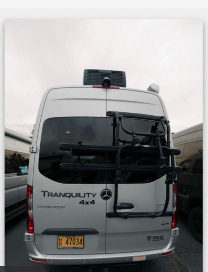 White Thor Tranquility 4x4 Mercedes-Benz Sprinter rv rental showing its rear, with a bike rack and rooftop AC unit.