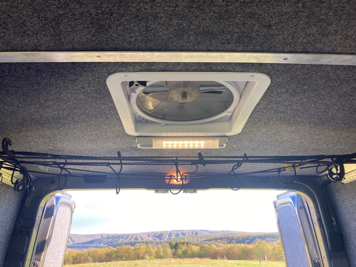 RV rental interior: ceiling fan, LED light, bungee storage. Open doors reveal beautiful nature views. — photo 16