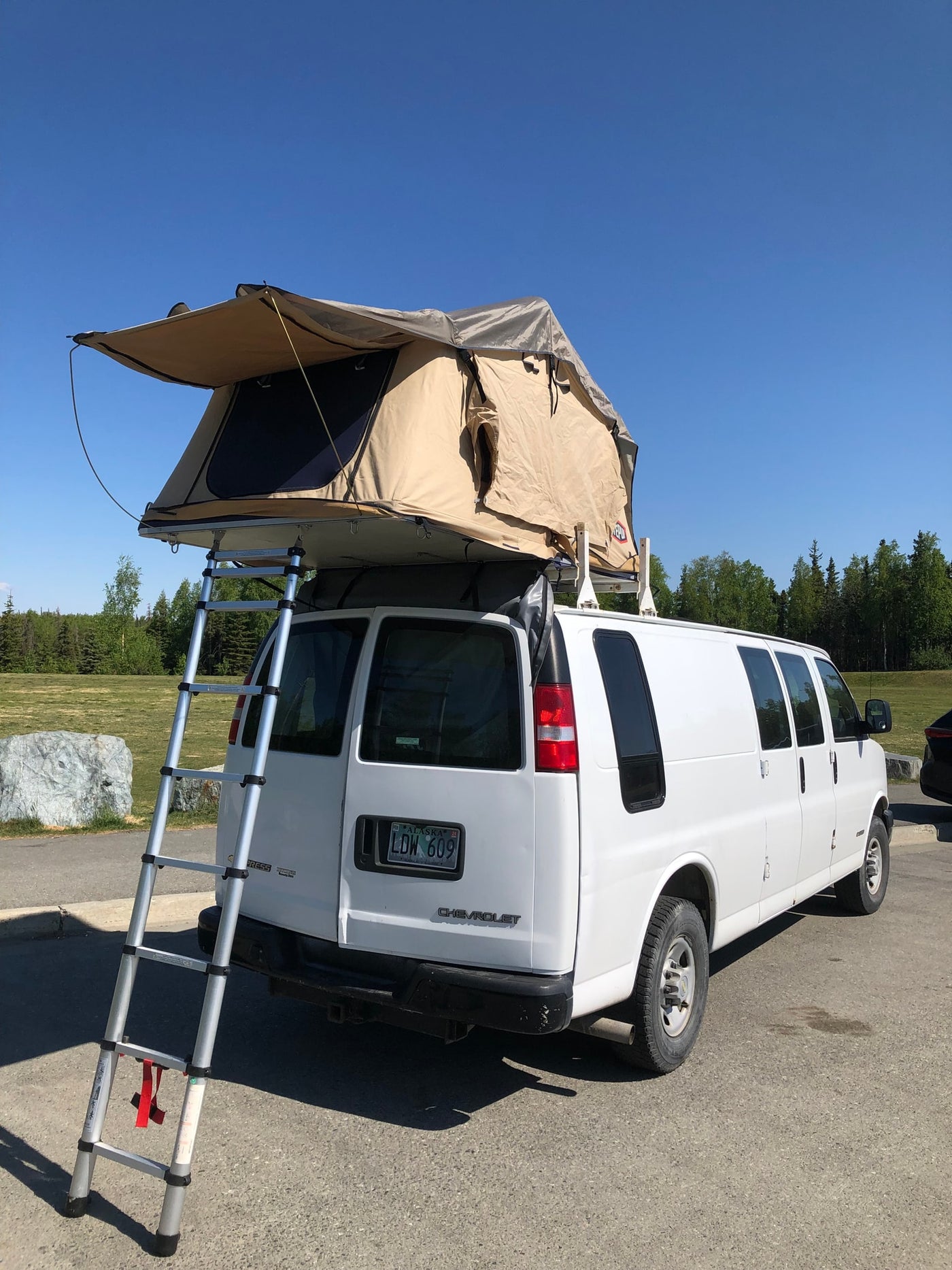 White Chevy van with rooftop tent and ladder, an ideal RV rental for camping adventures. — photo 6