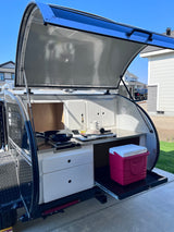  ready for RV rental adventures. Off-road capable.|Experience a compact RV rental teardrop trailer's open outdoor kitchen