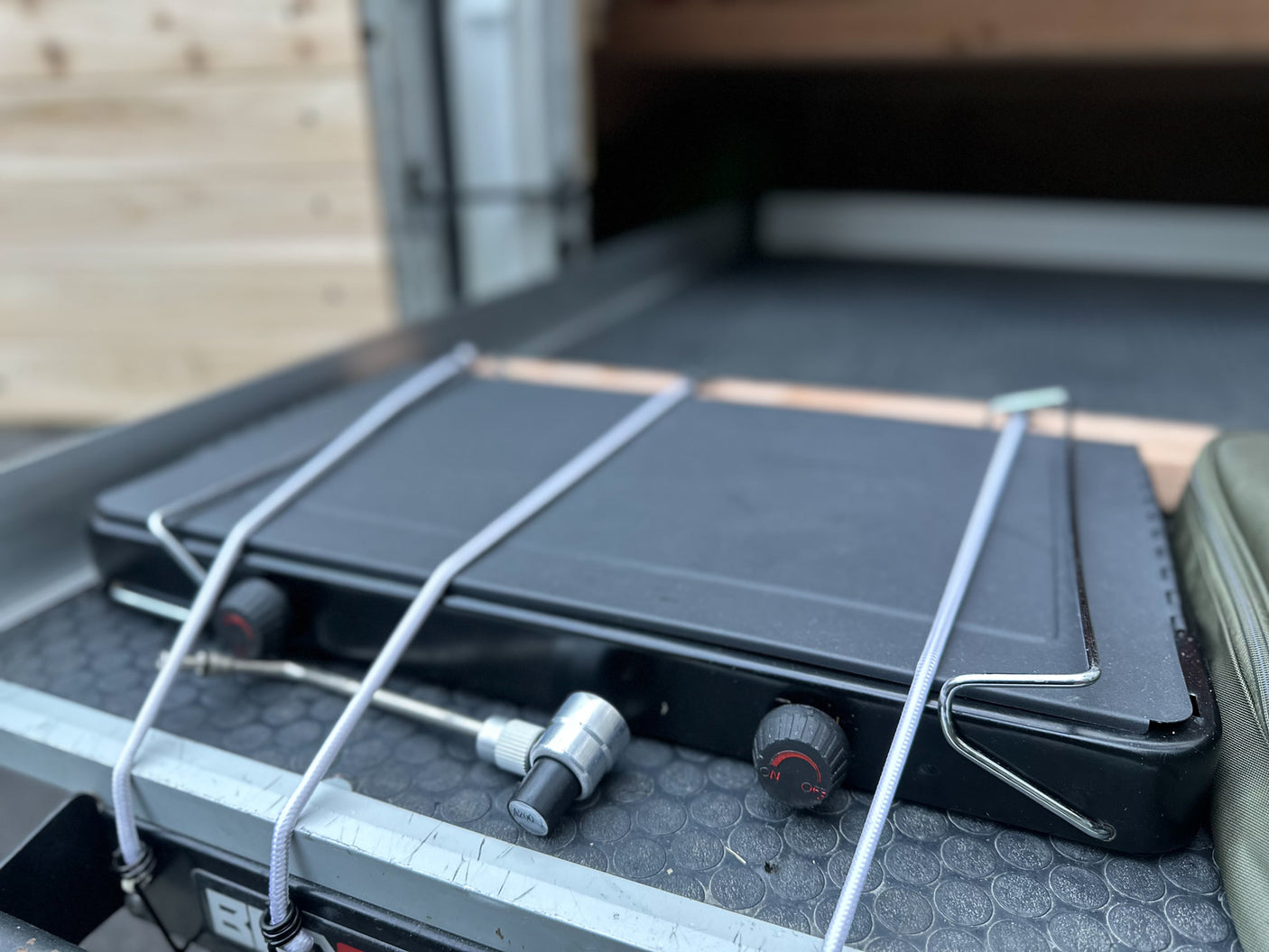 Portable camping stove secured in an RV rental pull-out drawer. Ready for outdoor cooking adventures.