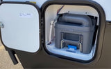 RV rental: External compartment open, revealing a gray cassette toilet for waste disposal and maintenance.