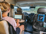 Working remotely in an RV rental! This image shows a person on a laptop inside a camper van, a mobile office setup with outdoor views.