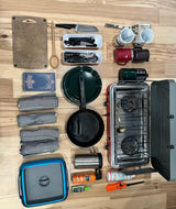 Prepped for an RV rental adventure! Camping kitchen essentials: stove, pans, cutlery, mugs, towels, and safety items laid out.