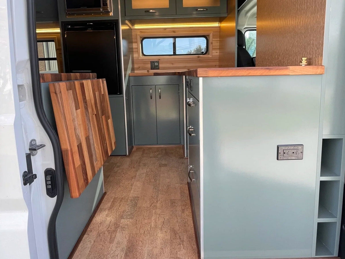  beside a cozy seating area.|Inside an RV rental: a Coleman Triton camping stove on a wood counter — photo 6