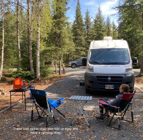Enjoying a peaceful RV rental campsite setup with comfortable rocker chairs and an outdoor cooking station amidst the trees.
