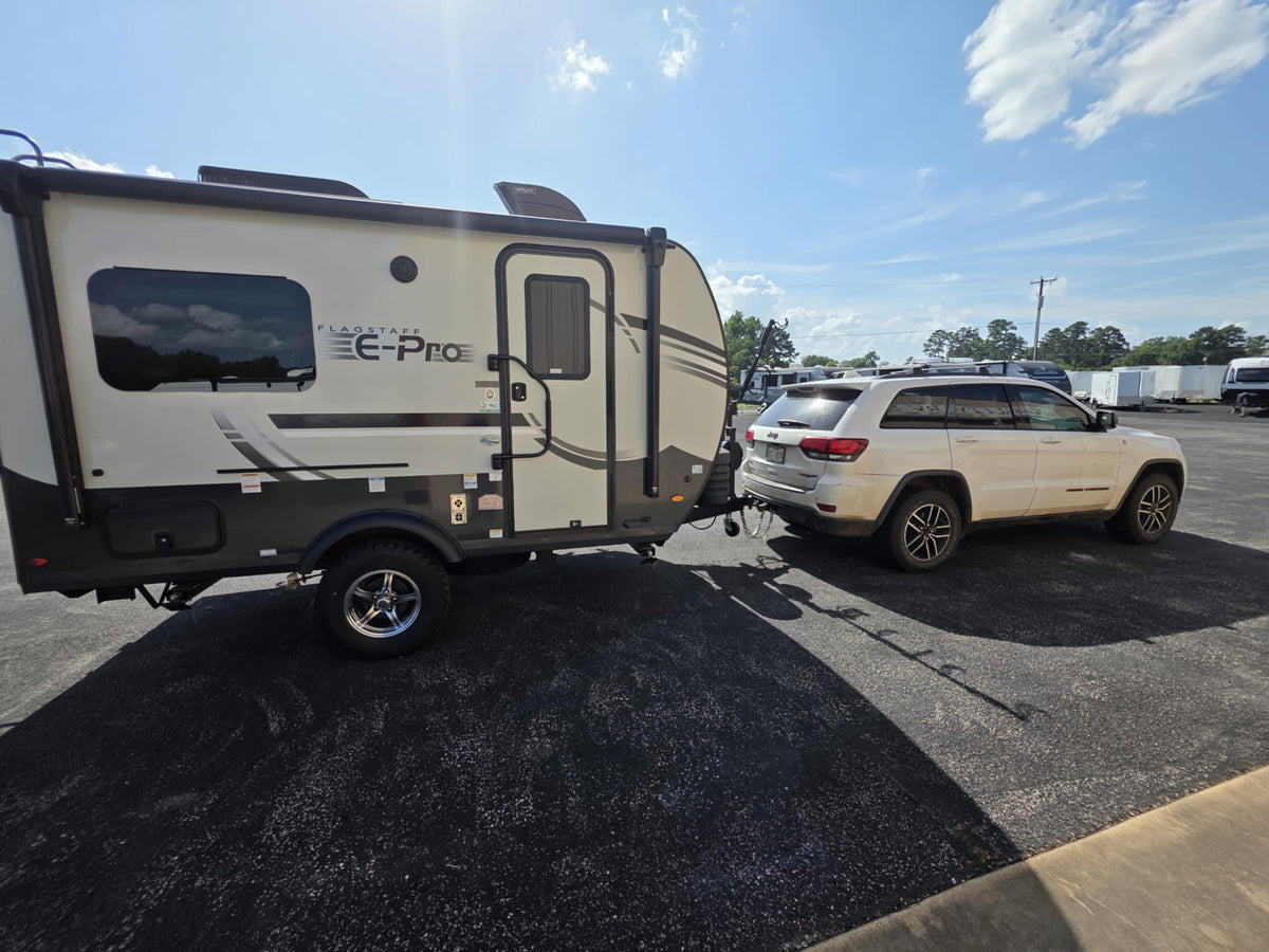 White SUV towing Flagstaff E-Pro travel trailer
