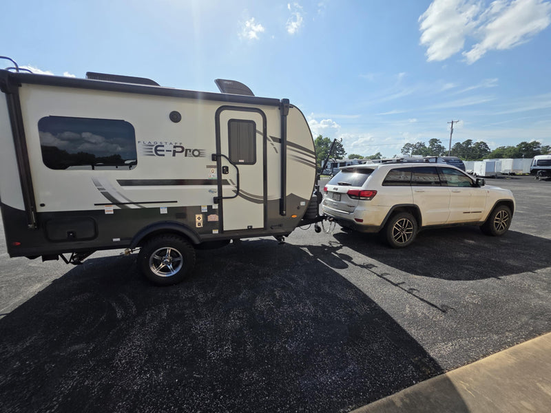 White SUV towing Flagstaff E-Pro travel trailer — photo 1