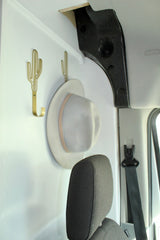 Stylish cactus hooks hold a hat in this organized RV rental interior, perfect for travel storage.