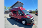 This vibrant red pop-top camper van, perfect for an rv rental adventure, is parked outdoors on a sunny day.