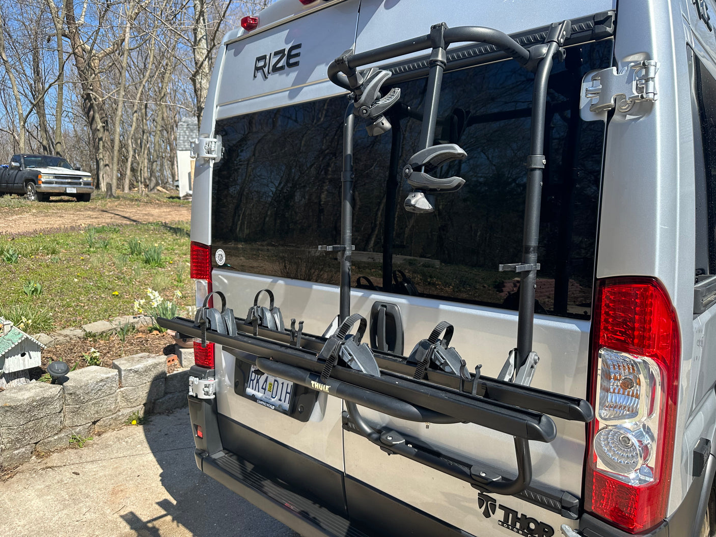 Rear view of a silver Thor Rize RV rental camper van, equipped with a Thule bike rack, ready for adventure.