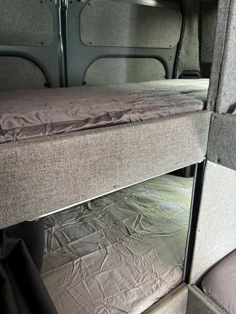 RV rental with comfortable bunk beds and grey bedding, perfect for family adventures.