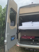 RV rental: Camper van interior with a comfortable bed and ample storage, ready for travel adventures.