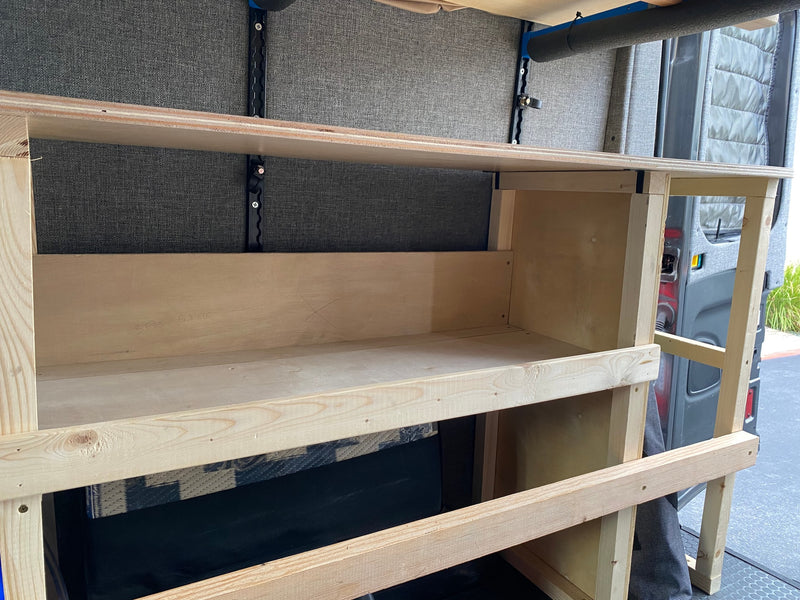 Custom wooden shelving inside an RV rental van, offering practical storage solutions in the built-out interior. — photo 27