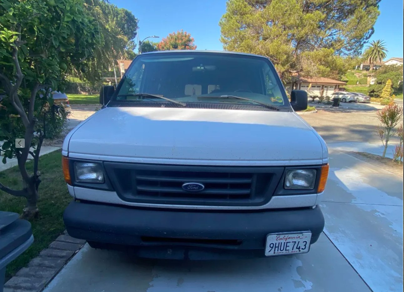  parked by mountains. Great RV rental for off-grid travel.|Front view of a white Ford Econoline van (CA plate 9HUE743) parked on a driveway — photo 2