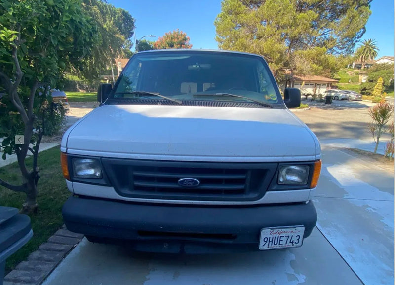  parked by mountains. Great RV rental for off-grid travel.|Front view of a white Ford Econoline van (CA plate 9HUE743) parked on a driveway — photo 2