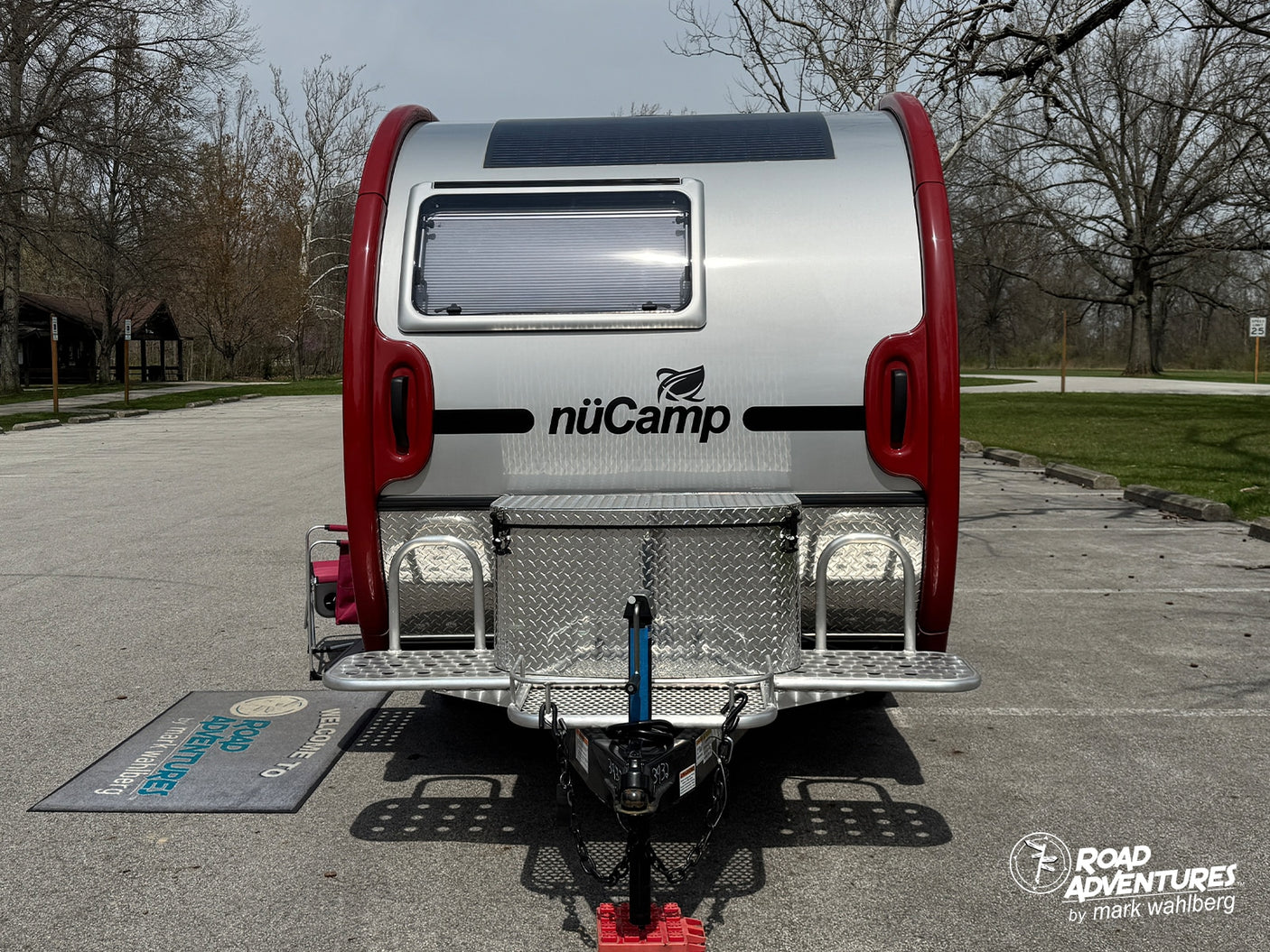 A shiny nuCamp teardrop travel trailer, an ideal **rv rental** for outdoor road trip adventures. Parked in a scenic lot.