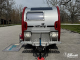 A shiny nuCamp teardrop travel trailer, an ideal **rv rental** for outdoor road trip adventures. Parked in a scenic lot.