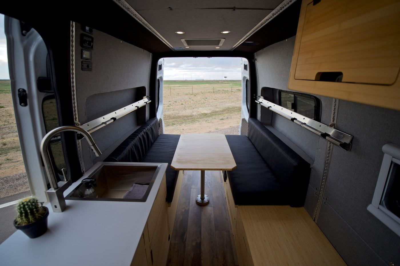  reveals a compact interior featuring a bed and kitchen setup.|Comfortable RV rental interior: bunk beds — photo 7