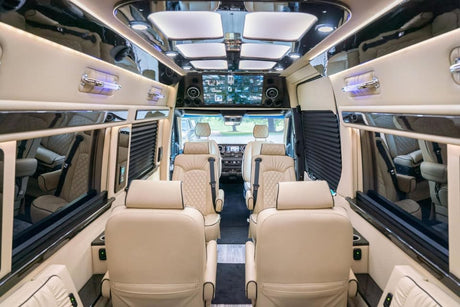 Experience luxury in this spacious RV rental interior, boasting plush cream seating, ambient lighting, and screens for ultimate comfort.